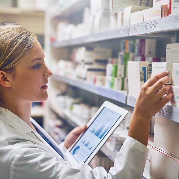 pharmacist grabbing medicine off shelf