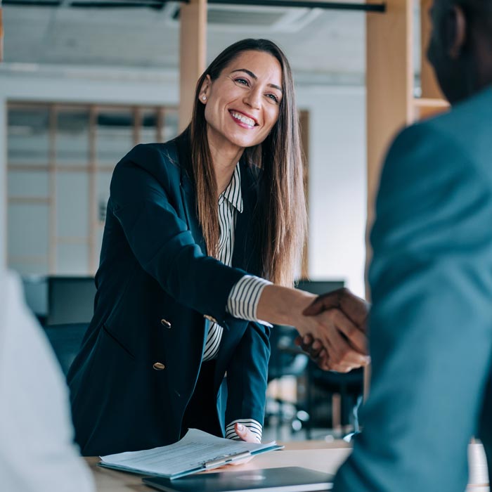 business woman giving handshake to client